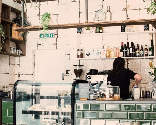 Charming café interior showcasing a barista preparing coffee behind the counter.