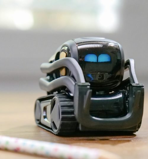 Explore the futuristic design of a miniature AI-powered robotic toy with modern technology elements.